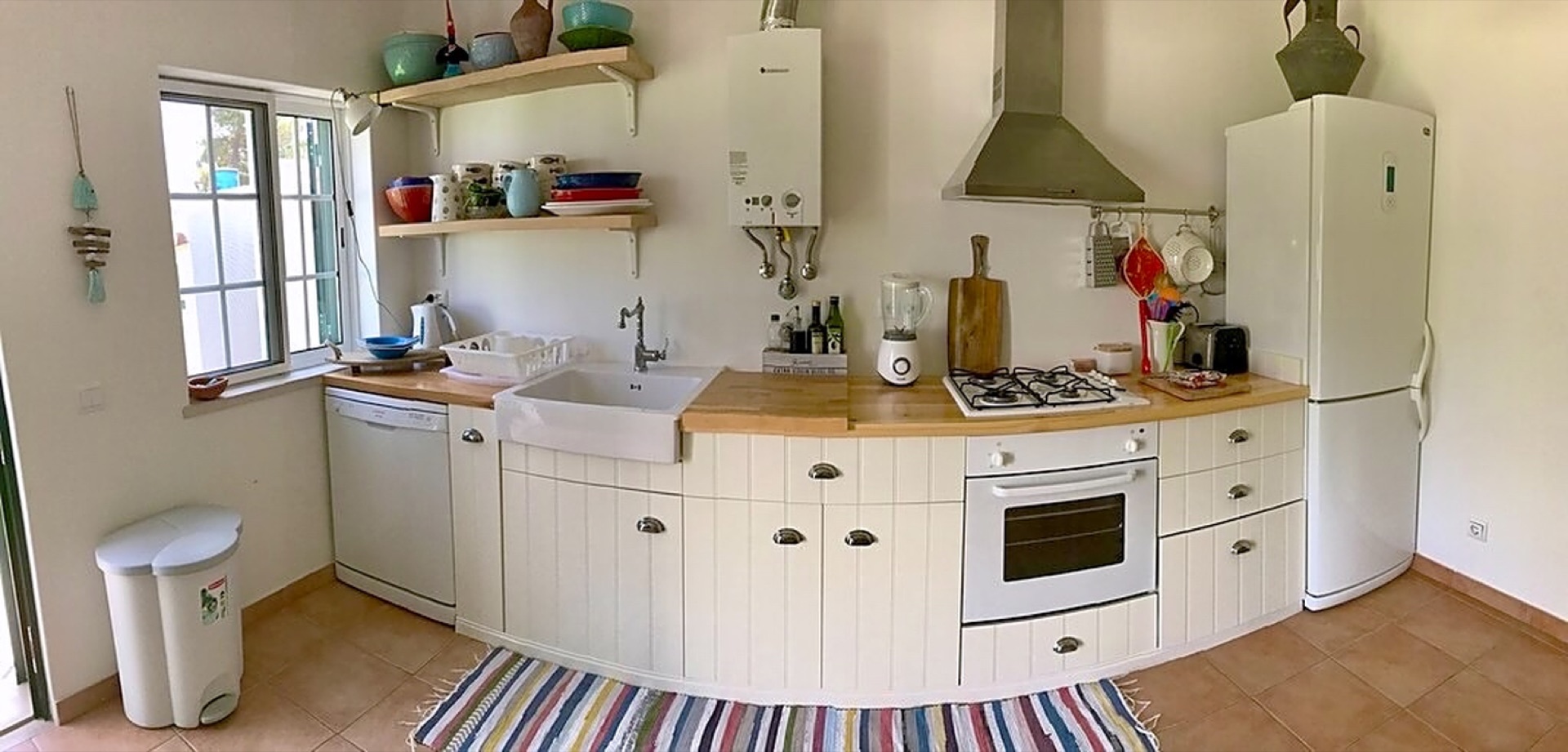 Well-equipped rustic kitchen with farmhouse sink and modern appliances