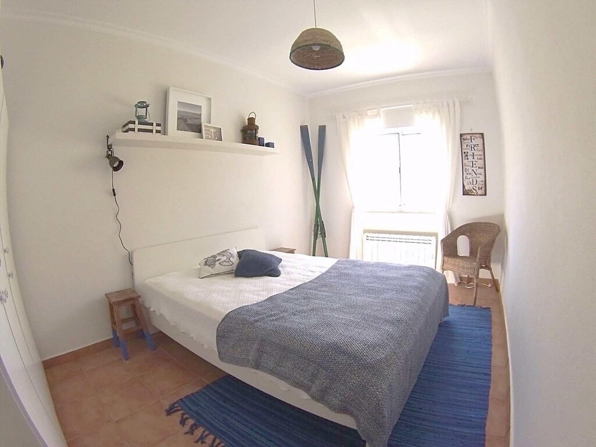 The Sea Room double bedroom with blue woven rug and wooden oars