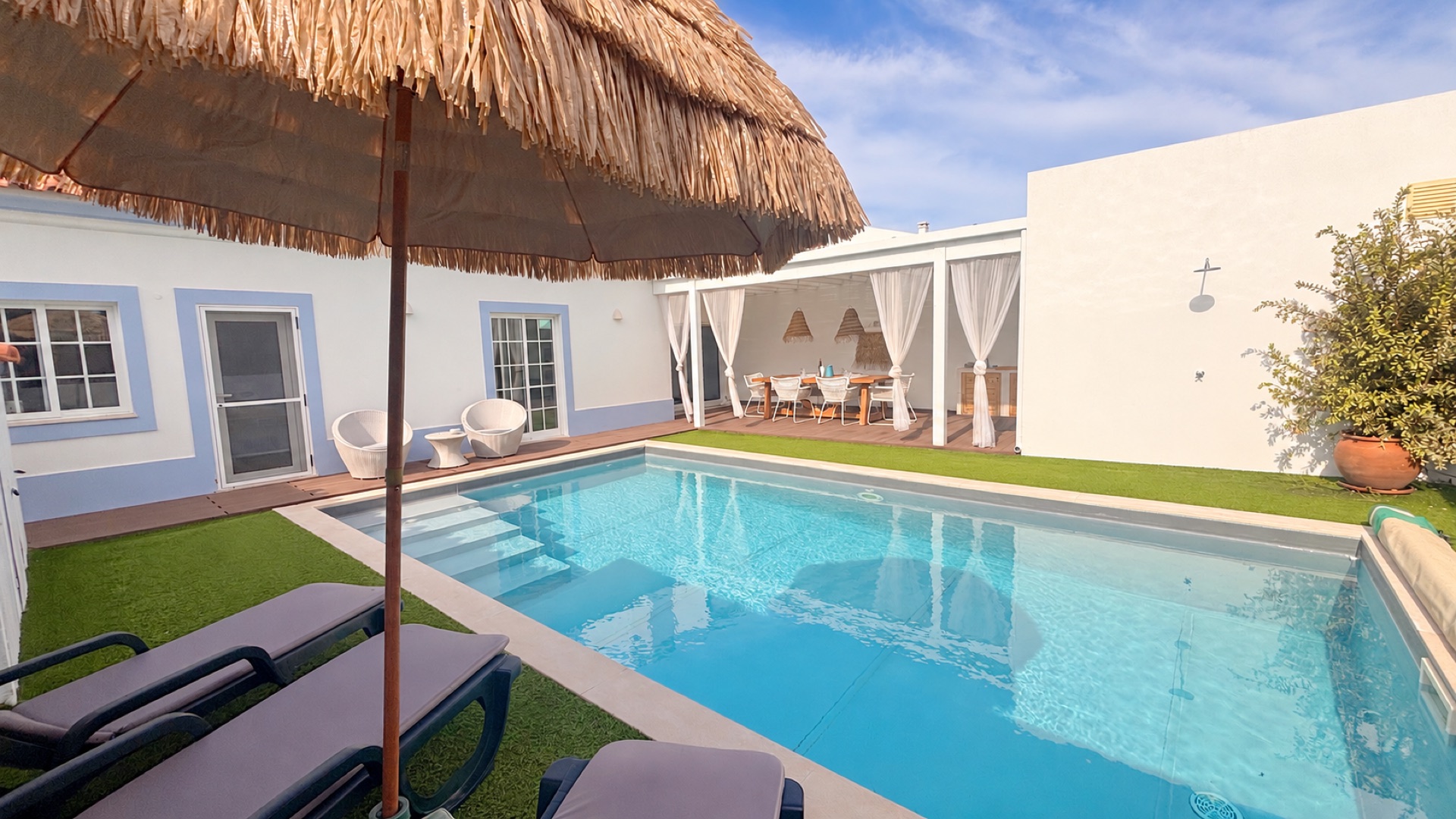 Sun loungers under thatched umbrella